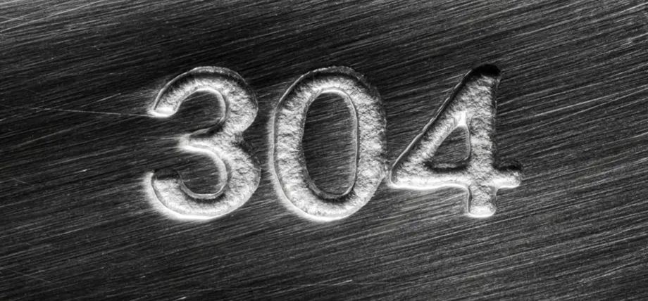 closeup of brush marks on a stainless steel surface with 304 engraved on it