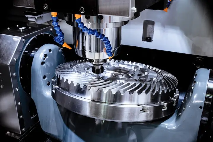 A part with many complicated features being machined on a 5-axis CNC machine