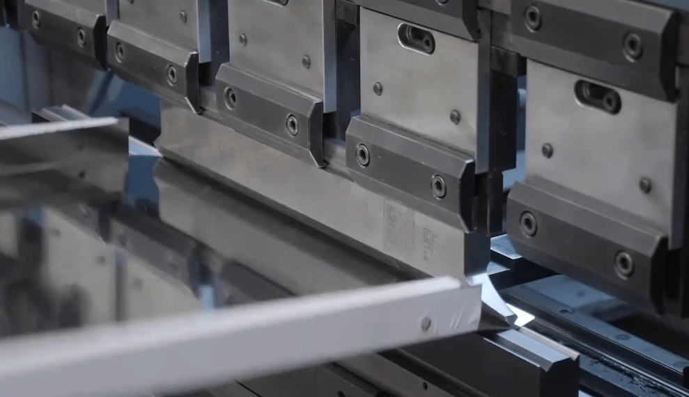 Close-up of CNC machine bending an aluminum sheet with precision