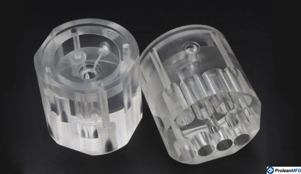 Two short, round CNC-machined polycarbonate parts with axial holes against a black background