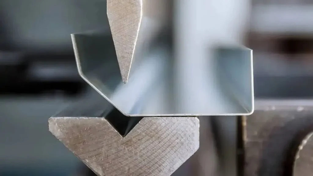 Metal sheet being bent into shape.