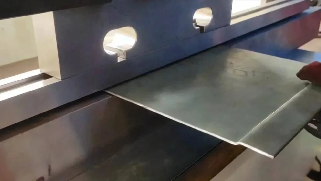 Close-up of metal sheet bending process.