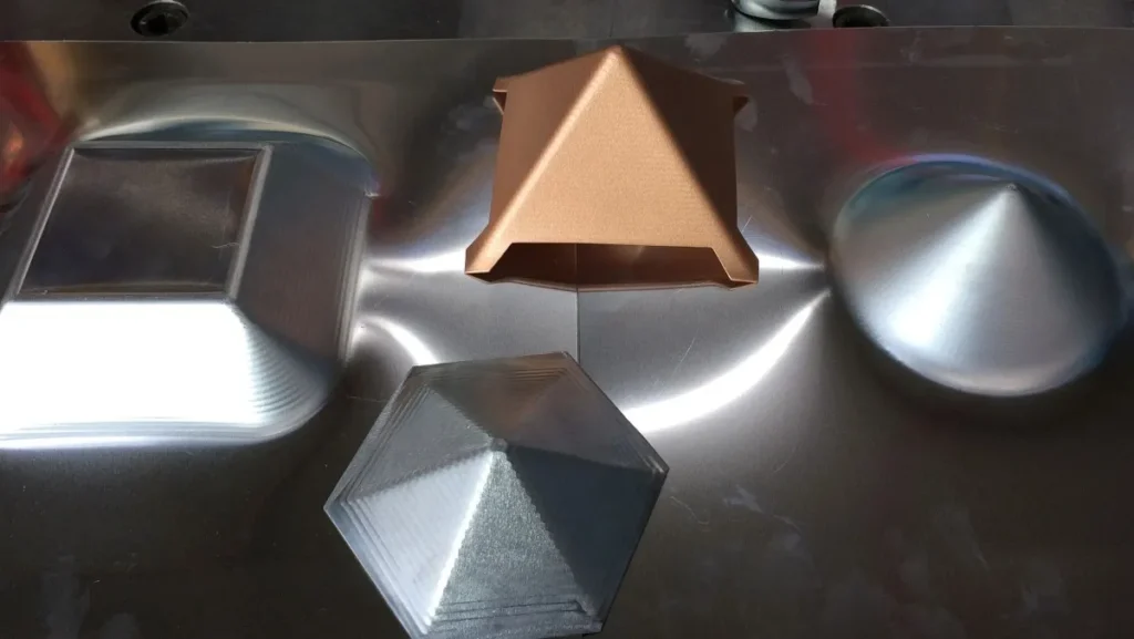 Metal sheet being formed into a square.