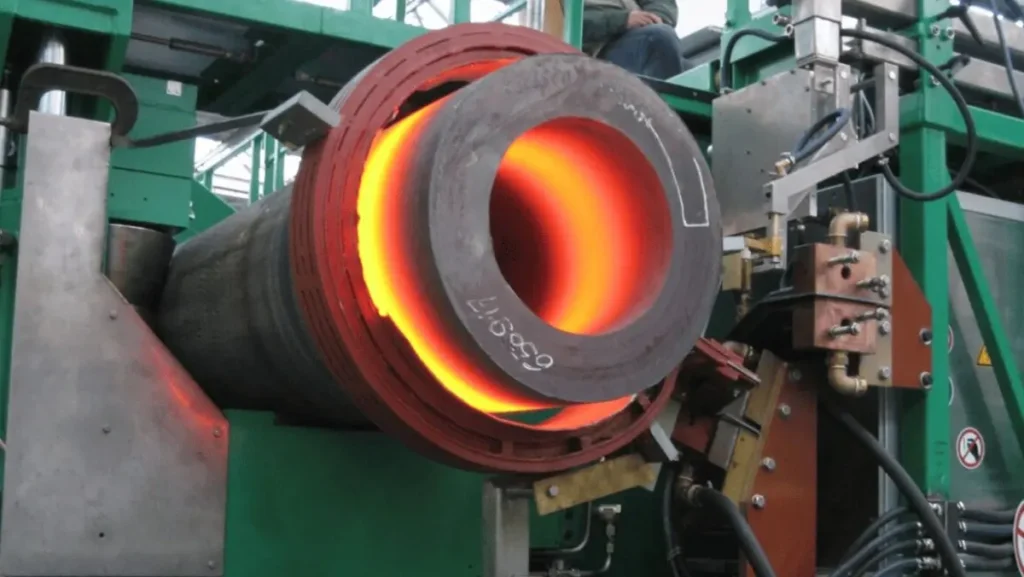 Hot metal pipe being induction bent.