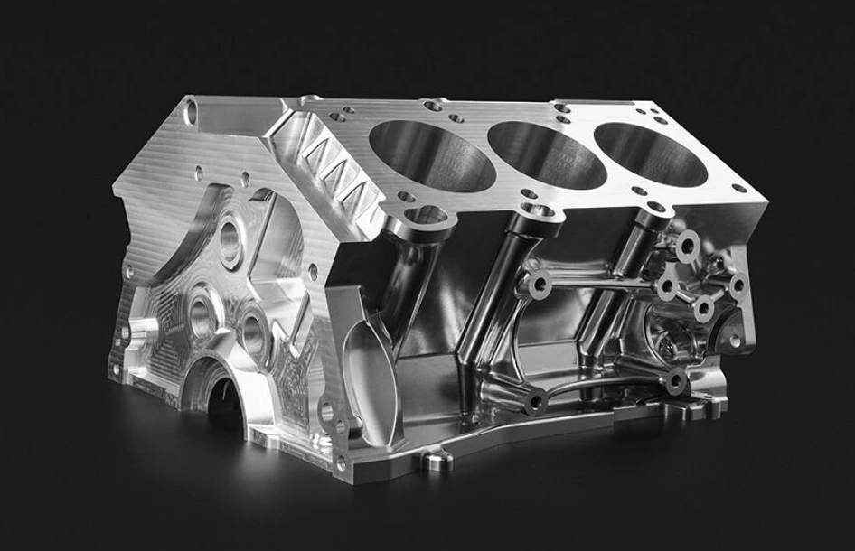 A shiny engine block with three piston holes and multiple smaller holes
