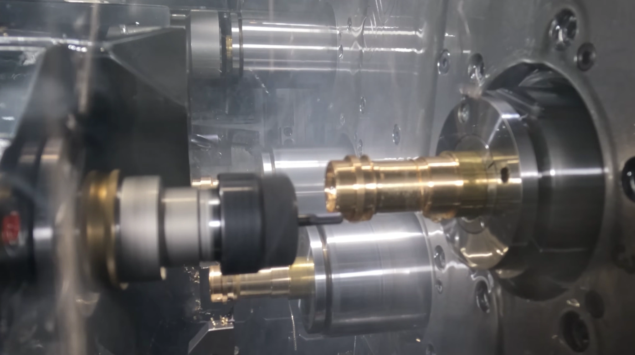 A precision metal part being machined using multi-axis Swiss turning.