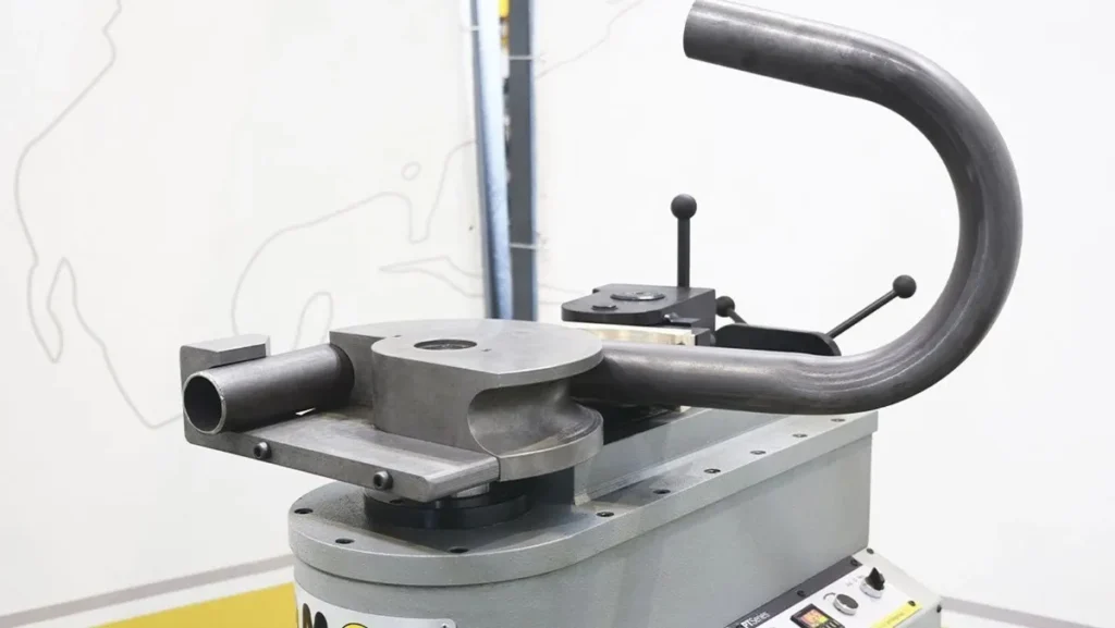 Metal tube being shaped by a rotary bender.
