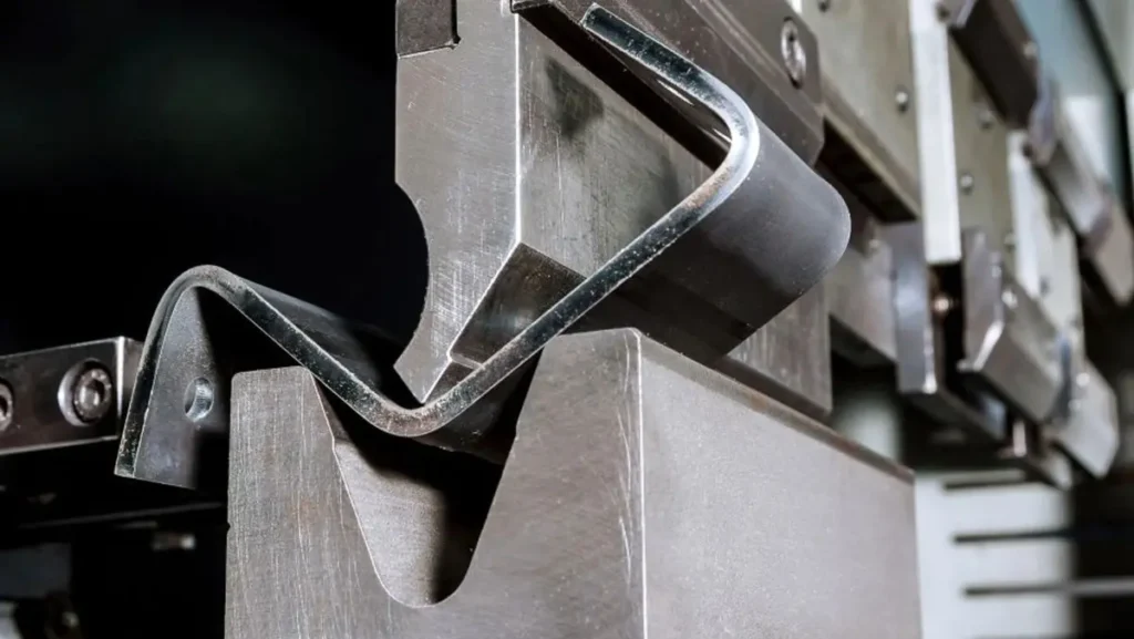 Close-up of steel being bent by machine.