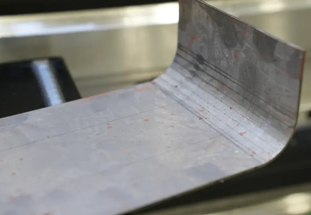 Sheet metal piece bent at one end into a right angle, illustrating U-bending