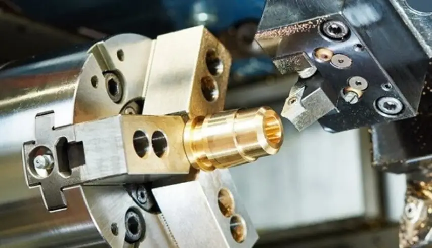 Brass cylindrical part being CNC turned on a lathe