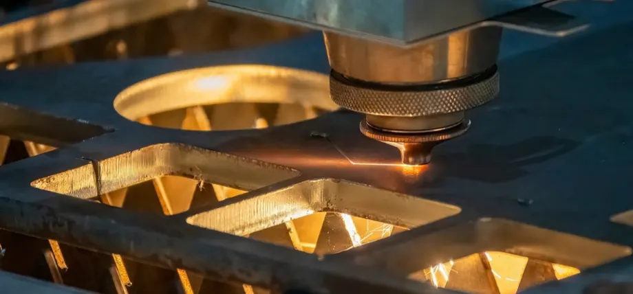 A close-up image of a laser cutting machine in operation, cutting geometric shapes