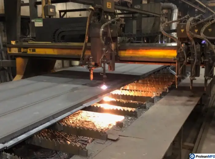 Plasma arc cutting a large metal sheet of stainless steel, with a glowing arc underneath the sheet