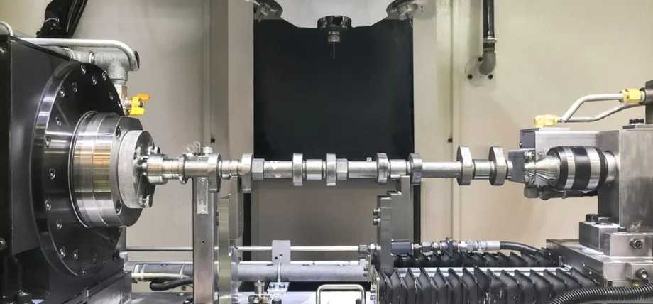 Camshaft centerd between a CNC turning center in an industrial setting.