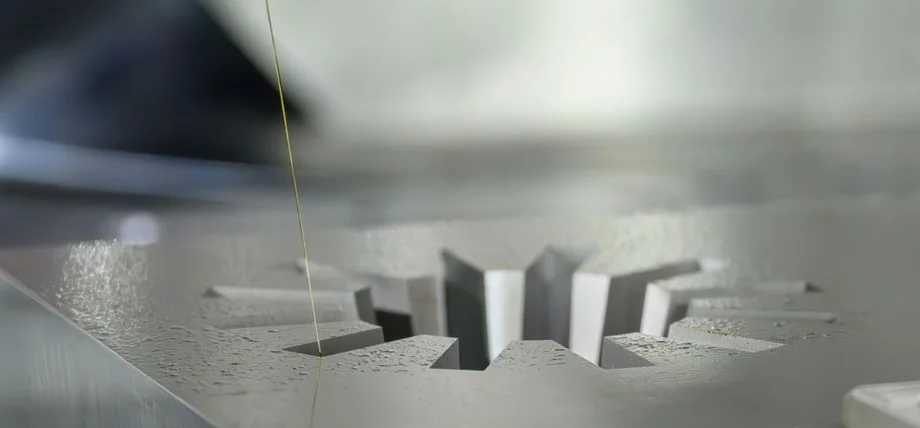 Close up of EDM wire cutting a metal workpiece