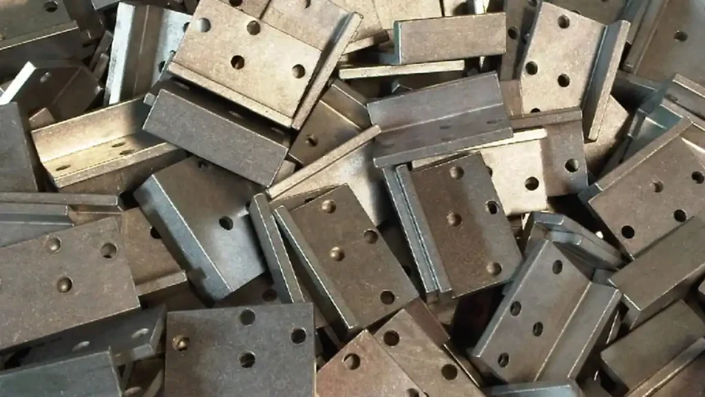 Pile of unpainted, unfinished metal brackets.