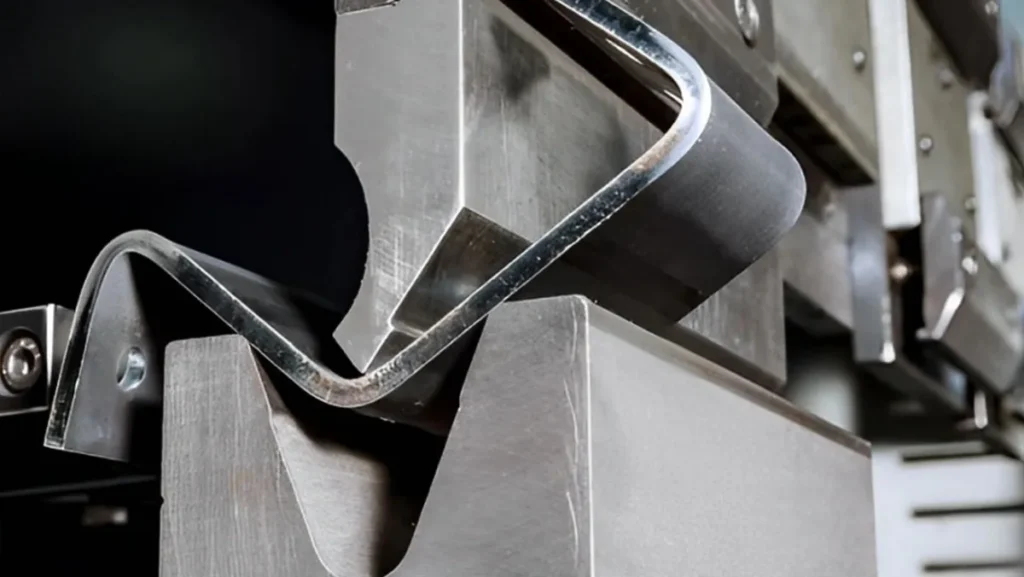 Metal sheet being bent by industrial machinery.