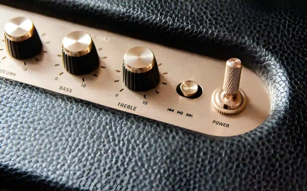 Close-up of a brass knob with volume, power, and bass buttons