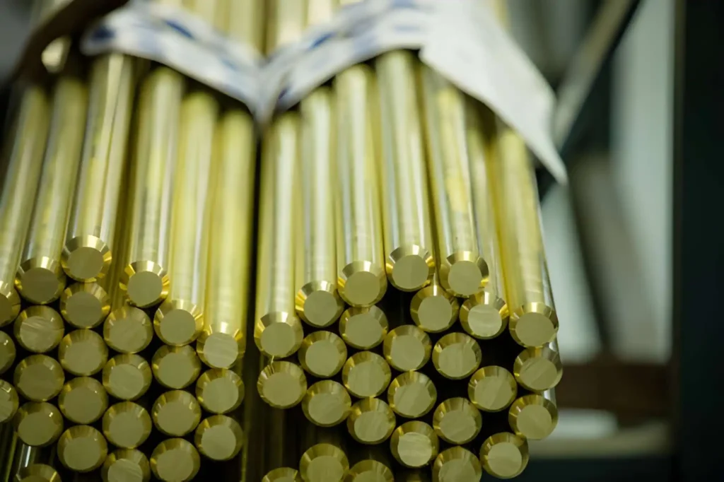 Raw brass rods stacked in a factory setting