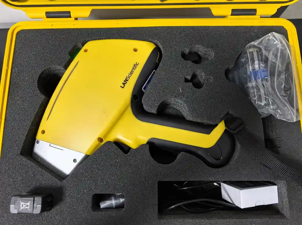 Portable metal spectrometer and accessories used for rapid alloy identification and material quality inspection in manufacturing and machining facilities.