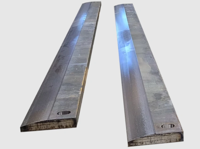 Two low-carbon steel A36 flat bars with face-milled top surfaces and slotted holes. 