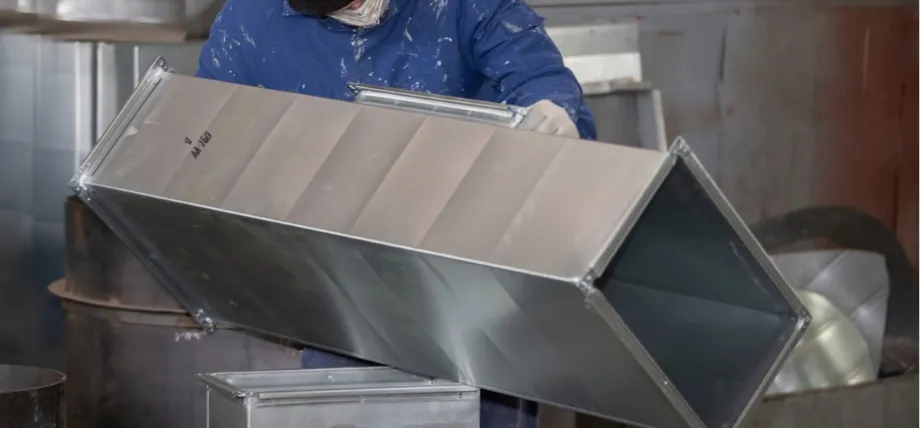 handling and positioning a large, rectangular galvanized sheet metal duct section with ribbed reinforcement