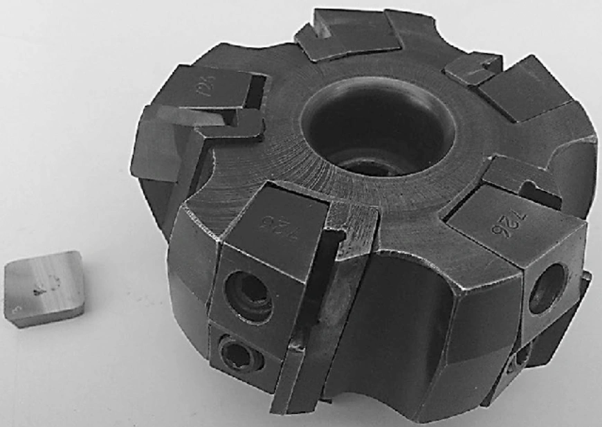 Tungsten carbide face milling cutter with brazed inserts, shown alongside a single loose carbide insert.