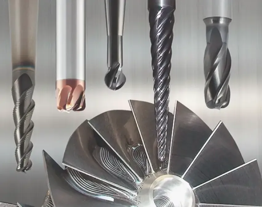 Several coated carbide end mills of various profiles, arranged above a precision-machined turbine impeller.