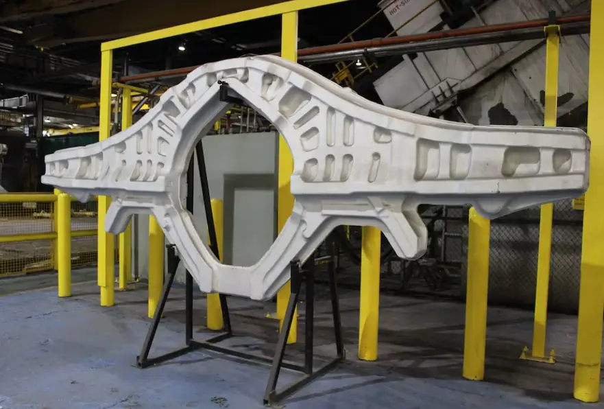 Large forged and CNC-machined aerospace structural frame with lightning pockets on the factory floor