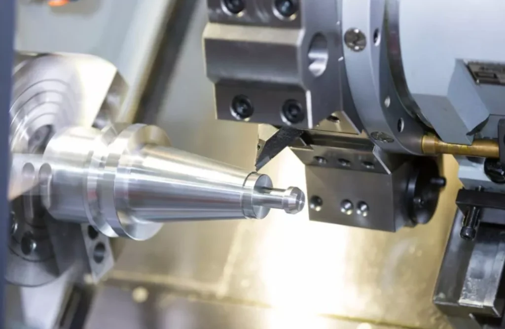 CNC lathe turning a tapered metal shaft with a carbide insert cutting tool.