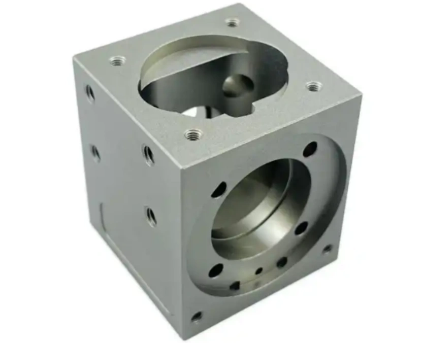 Precision CNC-machined aluminum block with complex internal cavities, circular bores, and threaded holes on multiple faces