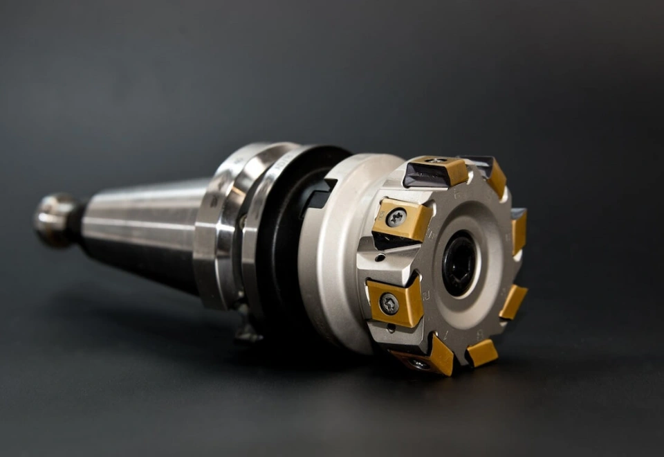 Peripheral milling cutter with gold-coated carbide inserts mounted on a BT/CAT shank arbor.