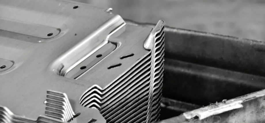 stack of identical precision metal stamped sheet metal parts, featuring thin, uniform aluminum or steel components with clean edges, punched holes