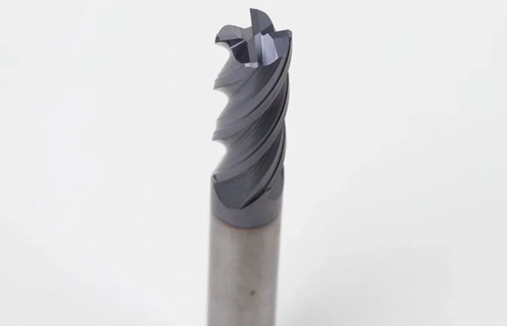 Four-flute square end mill with flat cutting tip and dark coating, viewed from a low angle