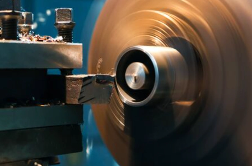 CNC lathe turning tool creating an undercut groove on a rotating cylindrical workpiece