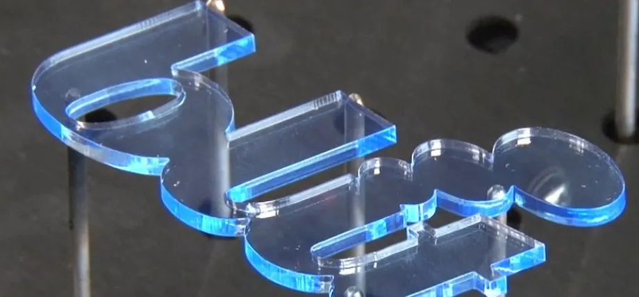 CNC-cut acrylic lettering with light-catching blue edges, demonstrating the clean finish achieved