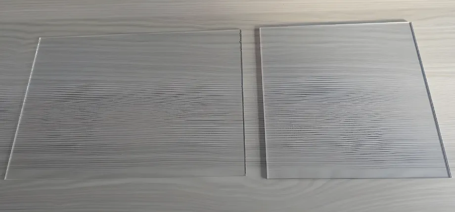 Side-by-side comparison of acrylic and polycarbonate sheets, highlighting the superior optical clarity of acrylic for CNC applications.