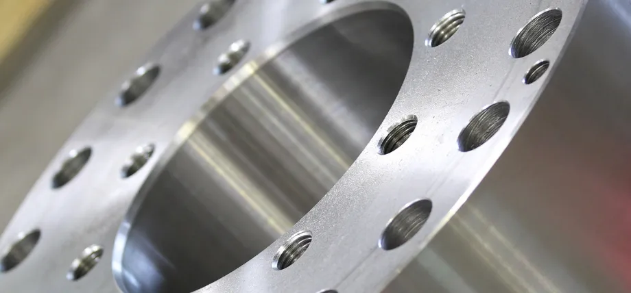 Close-up view of a high-precision aluminum flange featuring a large central bore, multiple threaded holes around the perimeter