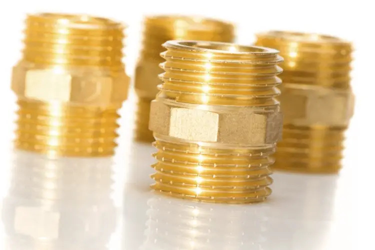 Four CNC-machined brass hex nipple fittings with male NPT threads for plumbing applications