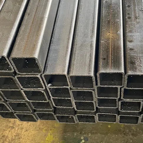 Square-shaped carbon steel bars stacked in bulk, showing raw industrial stock material used for machining and fabrication