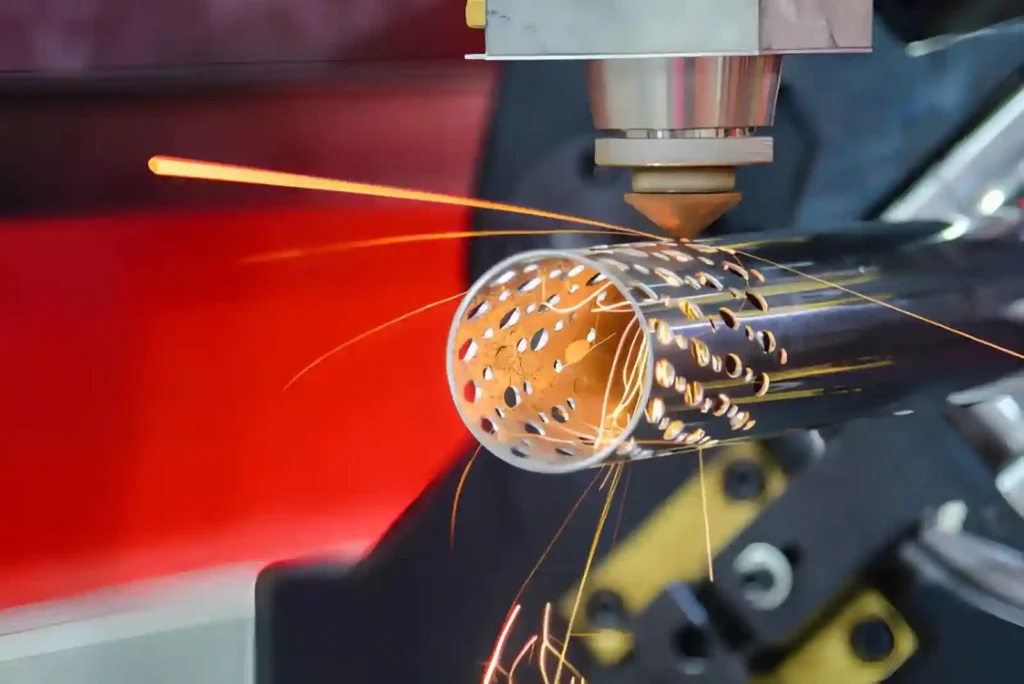 The image shows a laser cutting process creating precise holes inside a stainless steel tube.