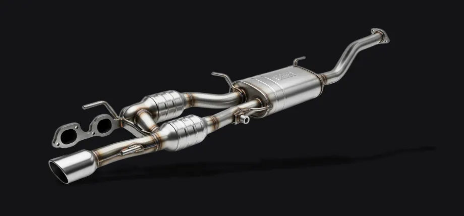 A complex automotive exhaust manifold assembly made of stainless steel with visible weld beads