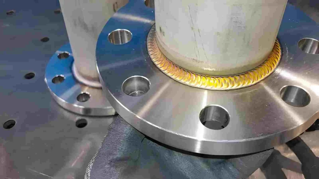 The image shows a TIG welding process on a stainless steel pipe joined with a stub end.