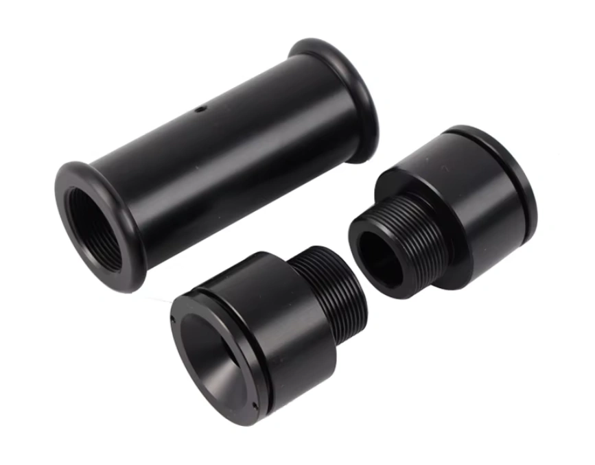 Three black ABS plastic prototype cylindrical threaded connector parts machined to precise tolerances 