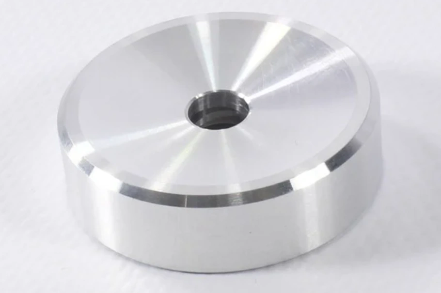 Mirror-polished CNC-machined aluminum disc part with a center bore hole.
