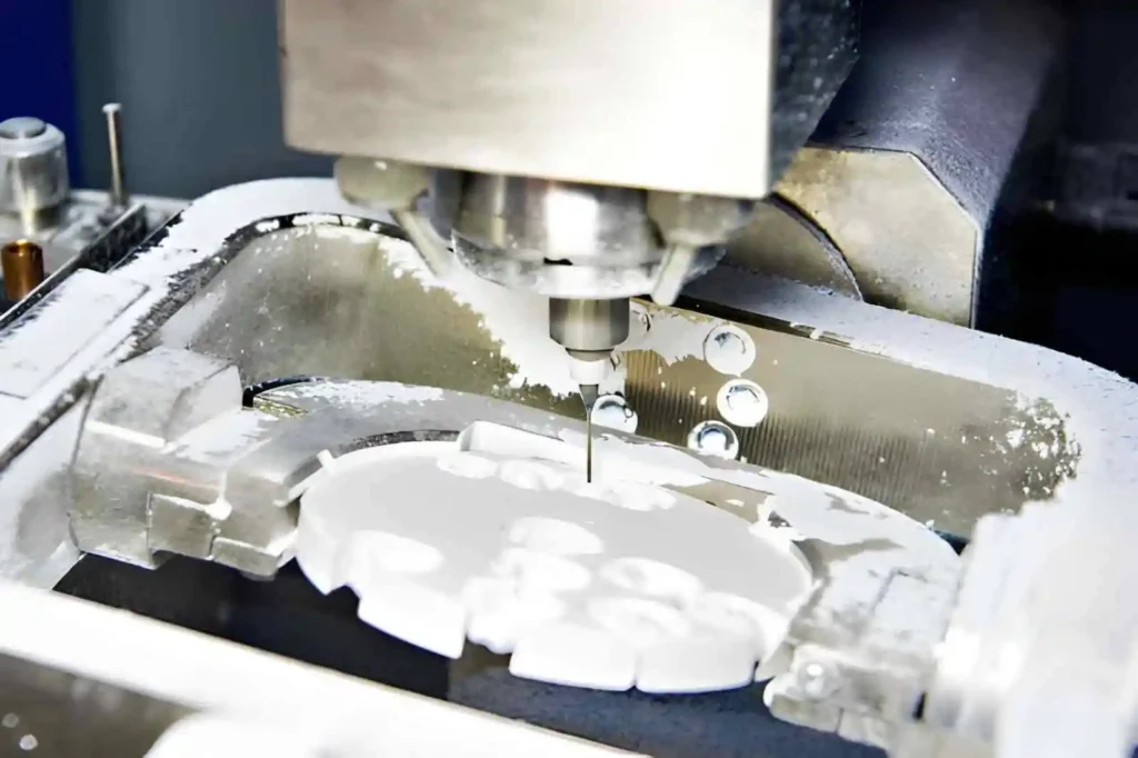 The image shows live CNC milling of a dental crown prototype