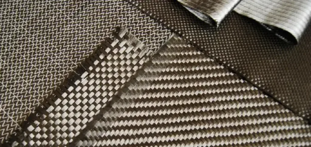 Multiple non-crimp carbon fiber fabric layers showing different weave patterns and orientations 