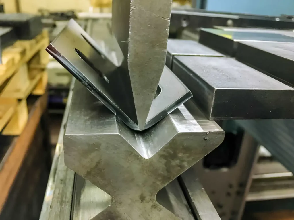 Hydraulic machine bends a sheet metal prototype to shape precise components.