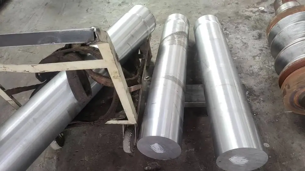 Bundle of polished stainless steel tubes with mirror finish showing hollow cross-sections against a gray background