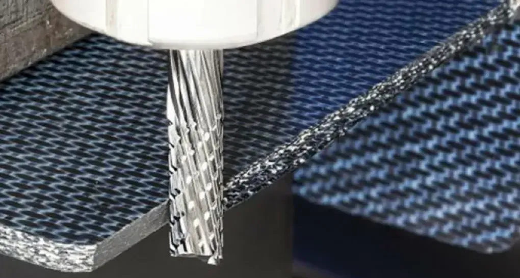 Close-up of a CNC end mill cutting through a machinable carbon fiber sheet