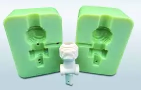 Green silicone mold halves with a white threaded plastic part. 
